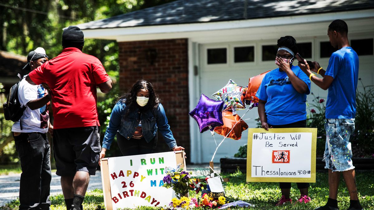Gathered on the front&nbsp;lawn, standing&nbsp;on the grass&nbsp;with&nbsp;balloons and flowers, a group of black demonstrators hold signs&nbsp;at&nbsp;a&nbsp;memorial for Ahmaud Arbery near where he was shot and killed in Brunswick, Georgia, on May 8.