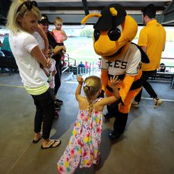 Calli Sorensen watches as her daughter Alexi Sorensen interacts with Bumble as fans enjoy a Salt Lake Bees baseball game at Smith's Ballpark in Salt Lake City on Wednesday, June 5, 2019.