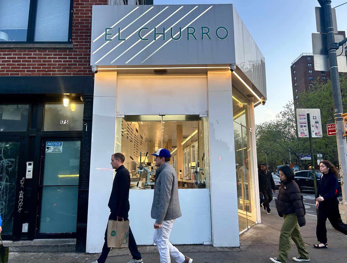 La gente camina frente a una tienda de churros en el Lower East Side llamada churro.