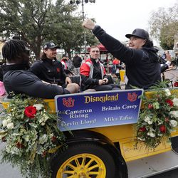 Utah Utes linebacker Devin Lloyd, Utah Utes quarterback Cameron Rising, Utah Utes wide receiver Britain Covey and Utah Utes defensive end Mika Tafua wave to fans during a parade at Disneyland in Anaheim, Calif., on Monday, Dec. 27, 2021, as part of events leading up to the Rose Bowl.