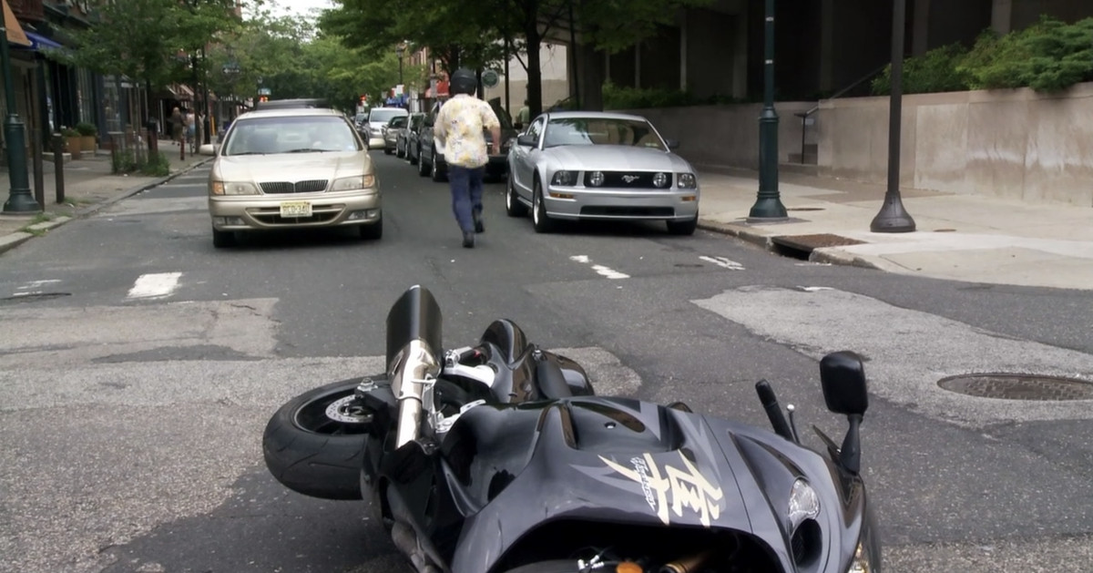 Mac s'enfuit dans la rue alors qu'une moto se trouve au milieu de la rue
