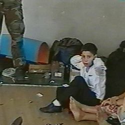 Hostages sit on a floor in a gym as a hostage-taker stands with his left foot on a book apparently with a device connected to a chain of explosives in the school in Beslan, Russia taken  in this undated image from television during the early part of the siege which began on  Sept. 1, 2004 and ended with over 300 people dead. Two suspects in the Boston Marathon bombing have been identified to The Associated Press as coming from a Russian region near Chechnya  In the past, insurgents from Chechnya and neighboring restive provinces in the Caucasus have been involved in terror attacks in Moscow and other places in Russia.