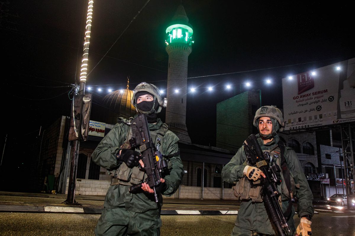 Israeli soldiers stand guard near the site of a shooting...