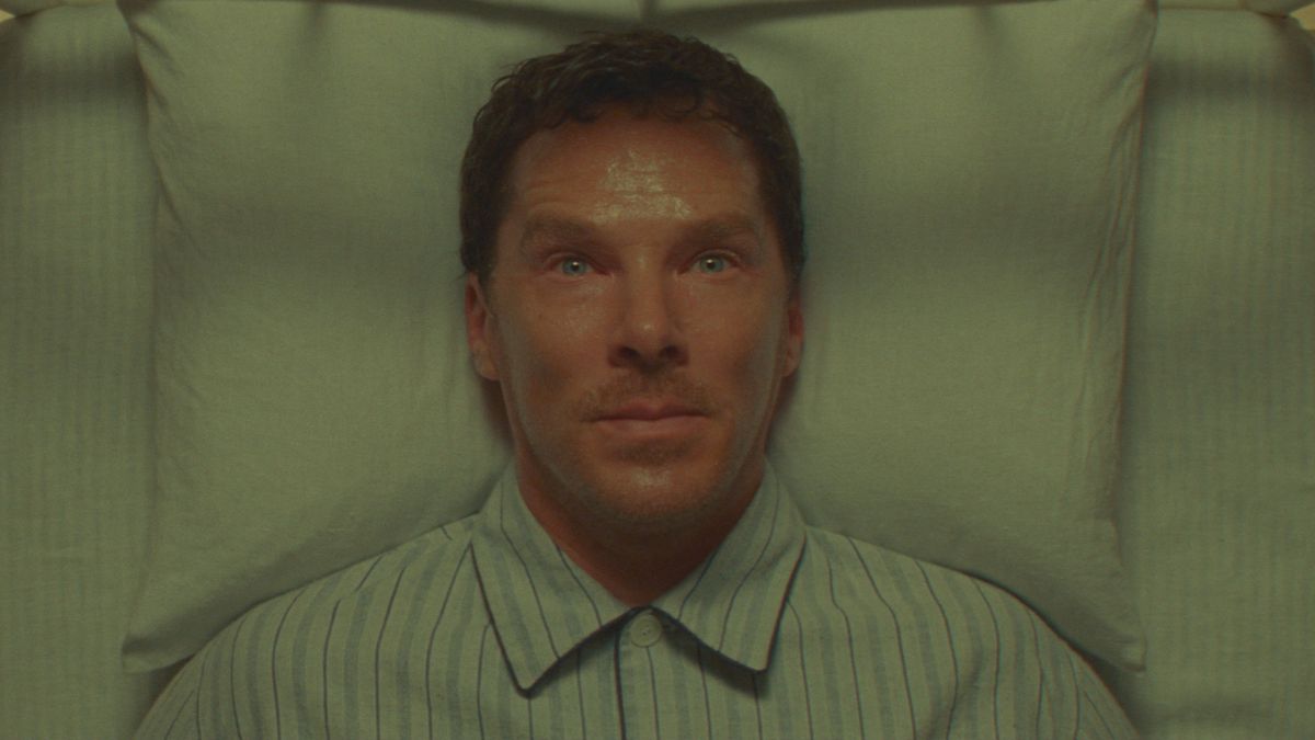 Harry (Benedict Cumberbatch) is seen in closeup, lying in his bed on his back, sweating and looking nervous in Wes Anderson’s Roald Dahl adaptation Poison