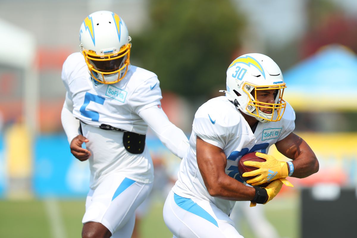 Tyrod Taylor #5 of the Los Angeles Chargers hands the ball of to Austin Ekeler #30 during the Los Angeles Chargers Training Camp at the Jack Hammett Sports Complex on August 20, 2020 in Costa Mesa, California.