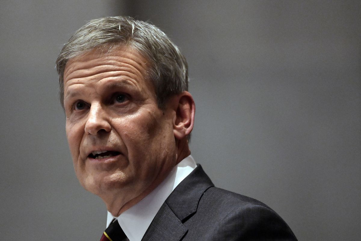 Bill Lee, pictured mid-speech with raised eyebrows, has grey hair and wears a grey suit jacket.