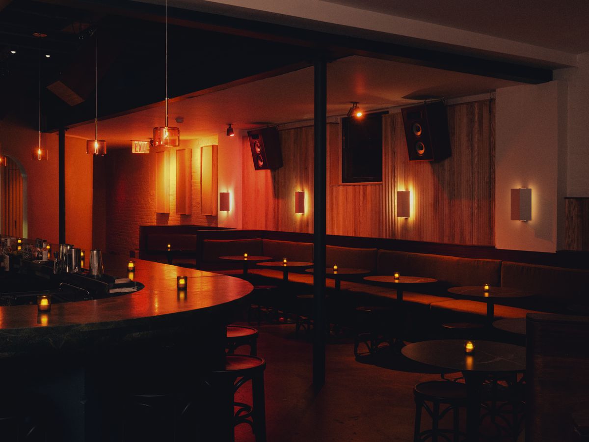A dim bar, Mr. Melo, is outfitted with speakers on its wall.