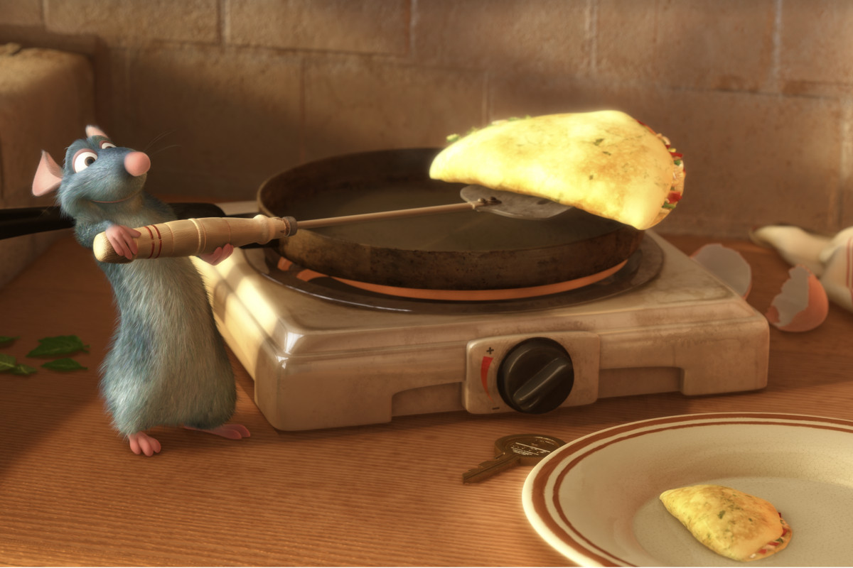 A still from the Movie Ratatouille depicting a cartoon rat holding a spatula with a piece of cheese on it.