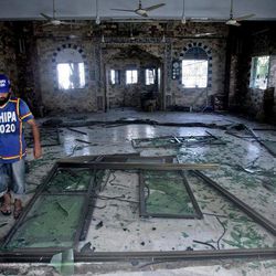 A Pakistani volunteer checks the damage inside a mosque caused by a bomb blast in Karachi, Pakistan, Wednesday, June 26, 2013. A bomb targeting a senior judge in the southern Pakistani city of Karachi wounded him and killed several security personnel on Wednesday, a senior government official said. 