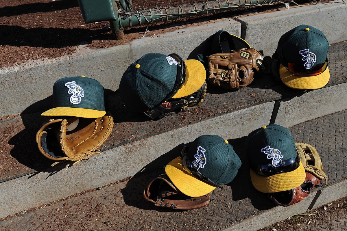 Oakland Athletics players leave their game hats and gloves on the steps of their dugout while playing the Los Angeles Angels during the sixth inning of their Cactus League game at Diablo Stadium in Tempe, Ariz., on Sunday, Feb. 24, 2013. (Jose Carlos Faja