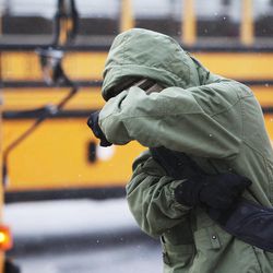A student fights the wind and blowing snow as he arrives at Farmington Junior High School in Farmington, Tuesday, April 9, 2013.