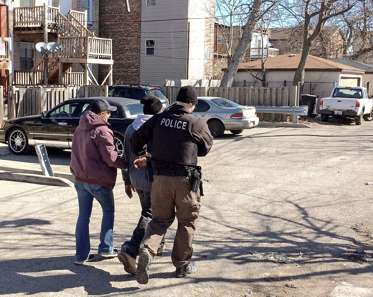 A suspected heroin buyer is taken into custody by Chicago police officers in the 3600 block of West Flournoy Street in the 11th District in 2017.