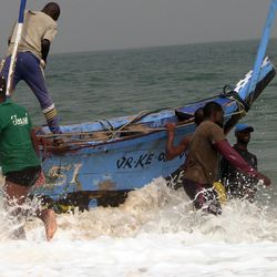 Fishermen seek to pull one of the giant fishing canoes on shore at Lake Volta in Ghana, the largest man-made lake in the world. 
