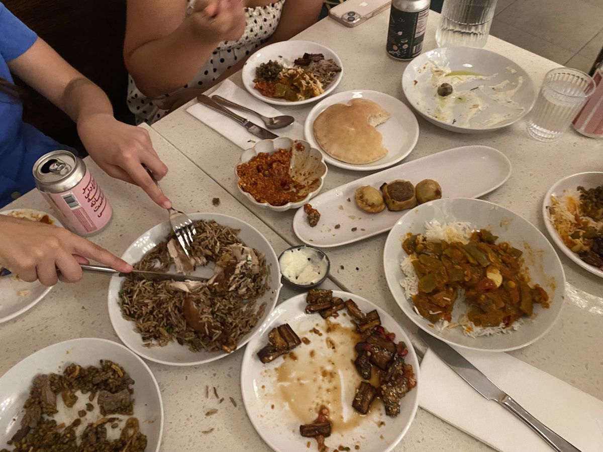 Hands wielding a fork and knife dig into the leftovers of a Lebanese feast at Nabila’s, a Carroll Gardens restaurant.
