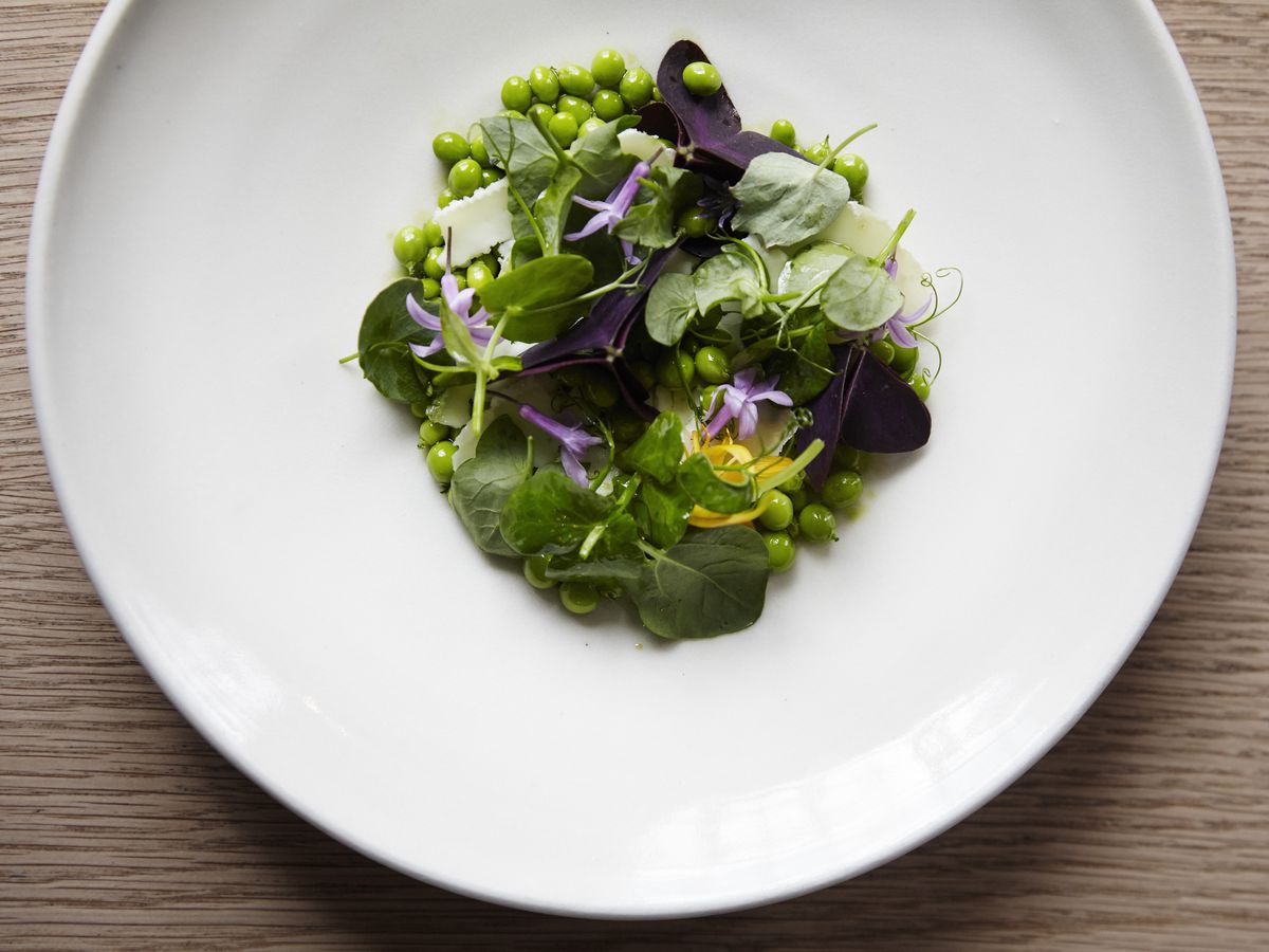 A plate of peas and pea shoots.