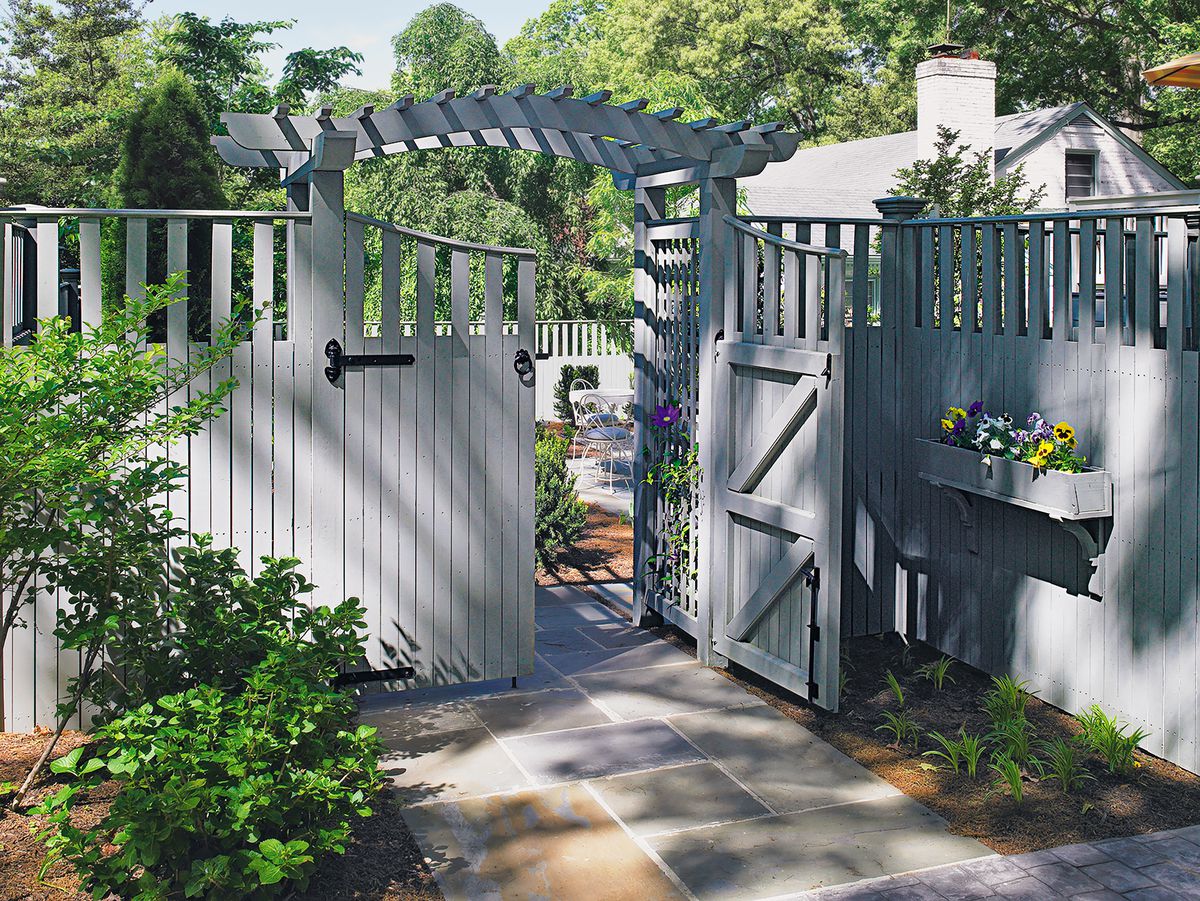 A white-grey fence decorated with planter box and plants for backyard privacy.