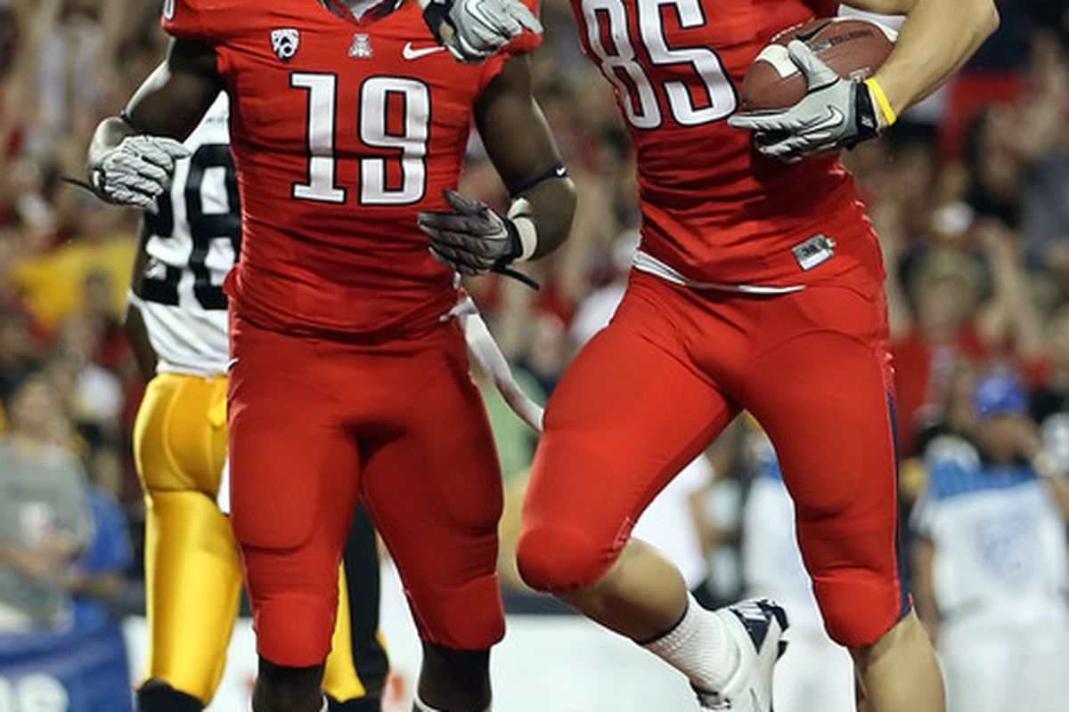 Wide receiver David Douglas #85 of the Arizona Wildcats celebrates with William Wright #19 after Douglas scored on a five-yard touchdown reception.