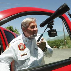 Provo Fire Chief Gary Jolley uses a spotting scope as search and rescue crews look for missing hiker Tyler Mayle near Y Mountain in Provo Tuesday, June 4, 2013. Mayle is a BYU student and has been missing since Saturday.