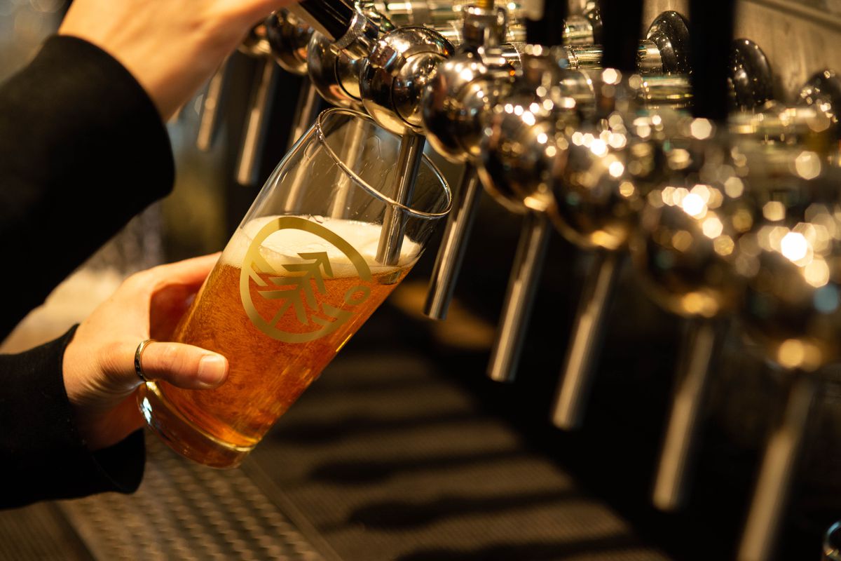A hand pours a beer from the tap at Grand Fir.