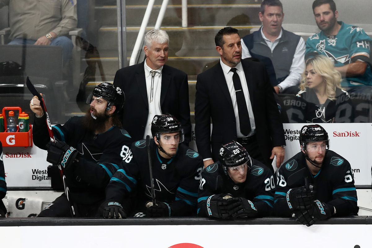 Interim head coach Bob Boughner (right) of the San Jose Sharks and associate coach Roy Sommer (left) watch their team play against the New York Rangers during Boughner’s first game as interim coach at SAP Center on December 12, 2019 in San Jose, California.