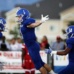 Braedon Wissler, second from left, of Bingham jumps in the air to celebrate with teammates after scoring a touchdown against East during high school football played in South Jordan on Friday, Aug. 25, 2017.