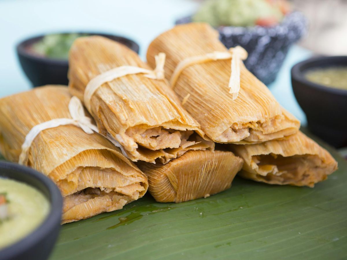 A pile of tamales wrapped in corn husks.