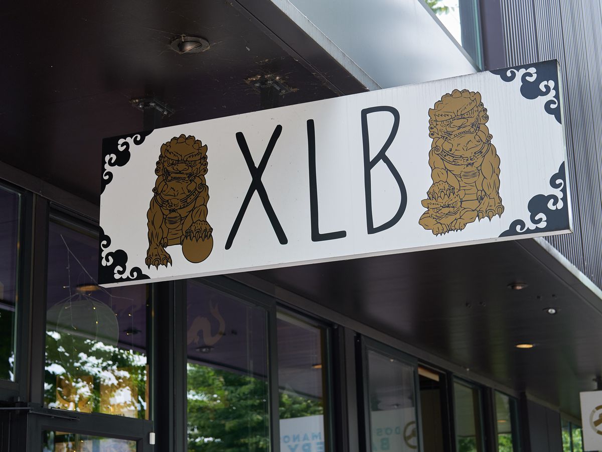 A sign reading “XLB” flanked by two stylized dragons.