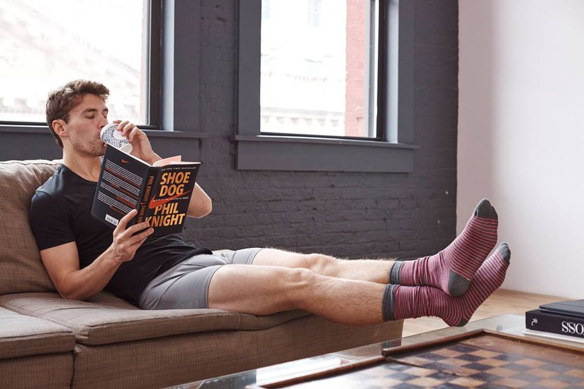 Man in underwear reading a book