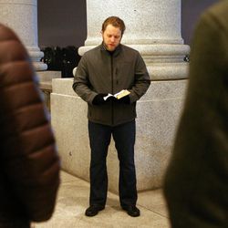 Keith Radke, pastor at the Calvary Chapel in Murray, reads during a vigil honoring those affected by the school shooting at Sandy Hook Elementary School in Newtown, Conn., outside of the state Capitol in Salt Lake City on Friday, Dec. 14, 2012.