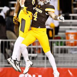 Wyoming wide receiver Tanner Gentry (4) celebrates with wide receiver Jake Maulhardt (83) after scoring a touchdown during the first half of an NCAA college football game in Laramie, Wyo., Saturday, Nov. 5, 2016. 