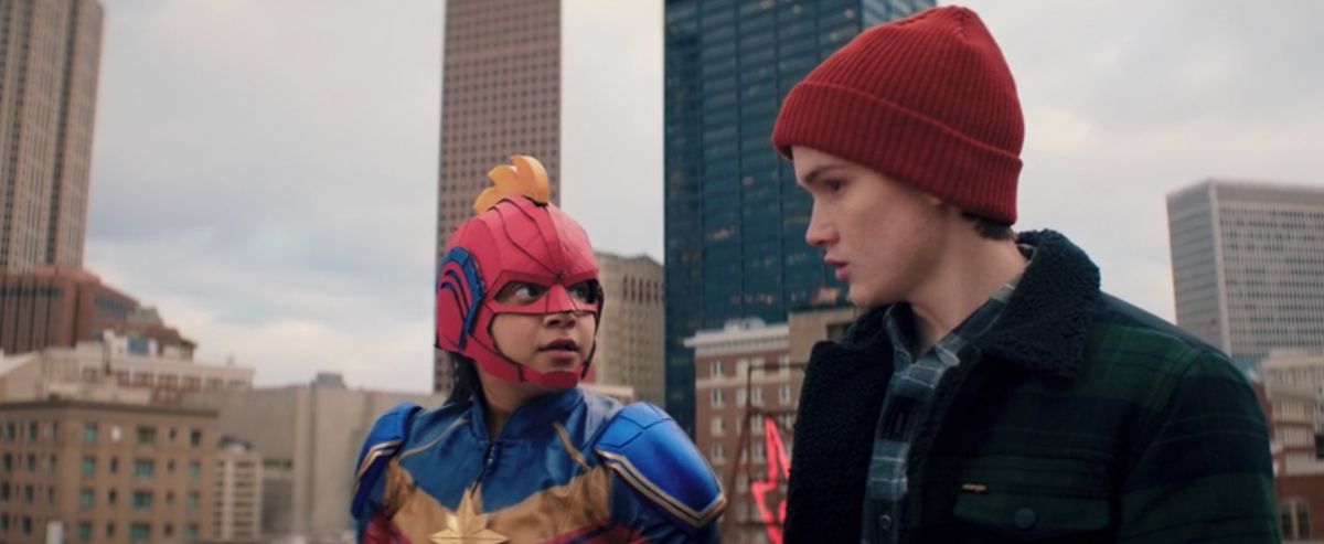 Ms. Marvel and her friend in a red beanie prepare to jump off a building