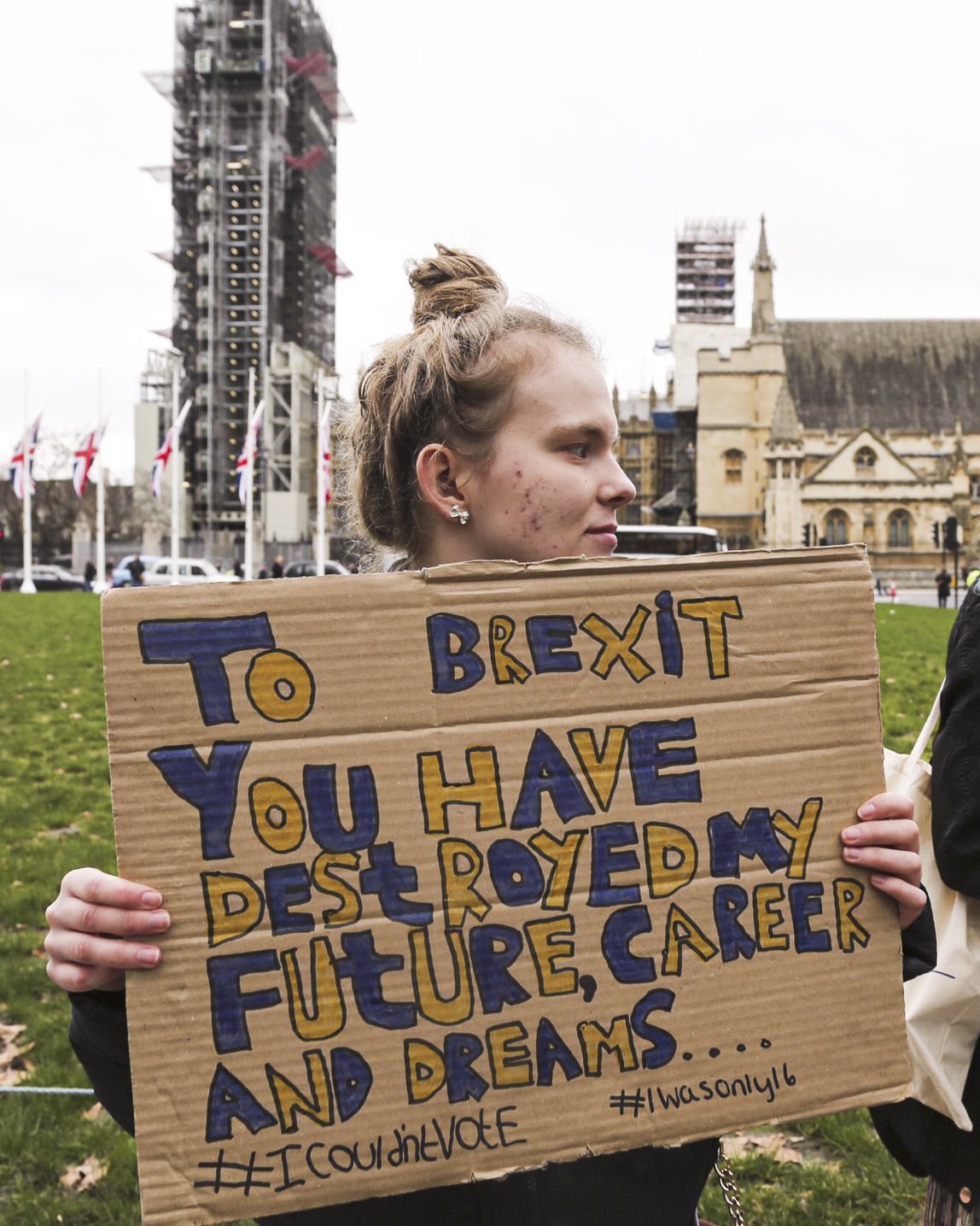 A person holding a sign saying “To Brexit you have destroyed my future, career and dreams” 