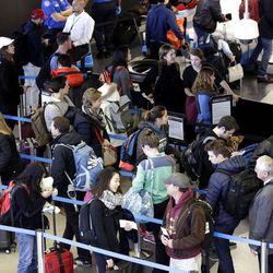 FILE - In this Sunday, Nov. 29, 2015, file photo, travelers line up at a security checkpoint area in Terminal 3 at O'Hare International Airport in Chicago.  The auto club AAA said Tuesday, Nov. 15, 2016, that it expects 1 million more Americans to venture at least 50 miles from home, a 1.9 percent increase over last year. 