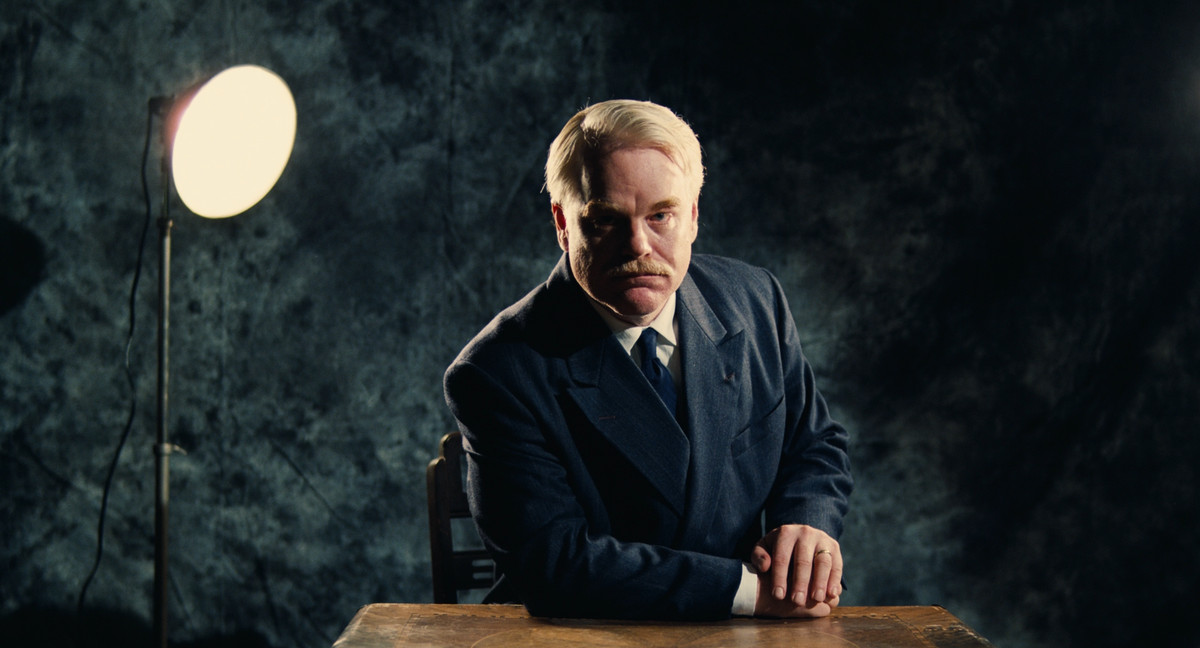 Philip Seymour Hoffman as Lancaster Dodd, posing for a photo in The Master