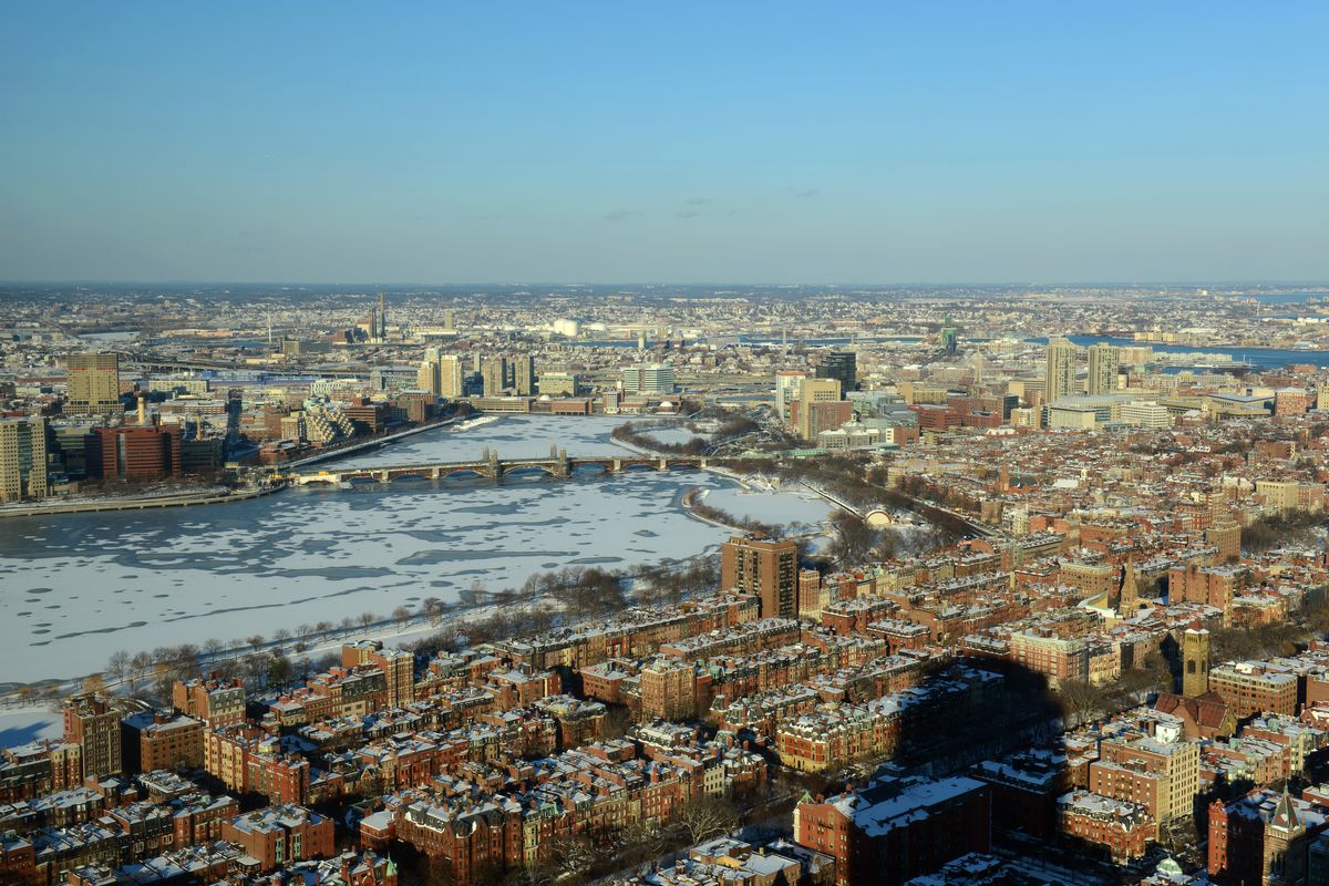 Aerial shot of two dense cities separated by a frozen river.