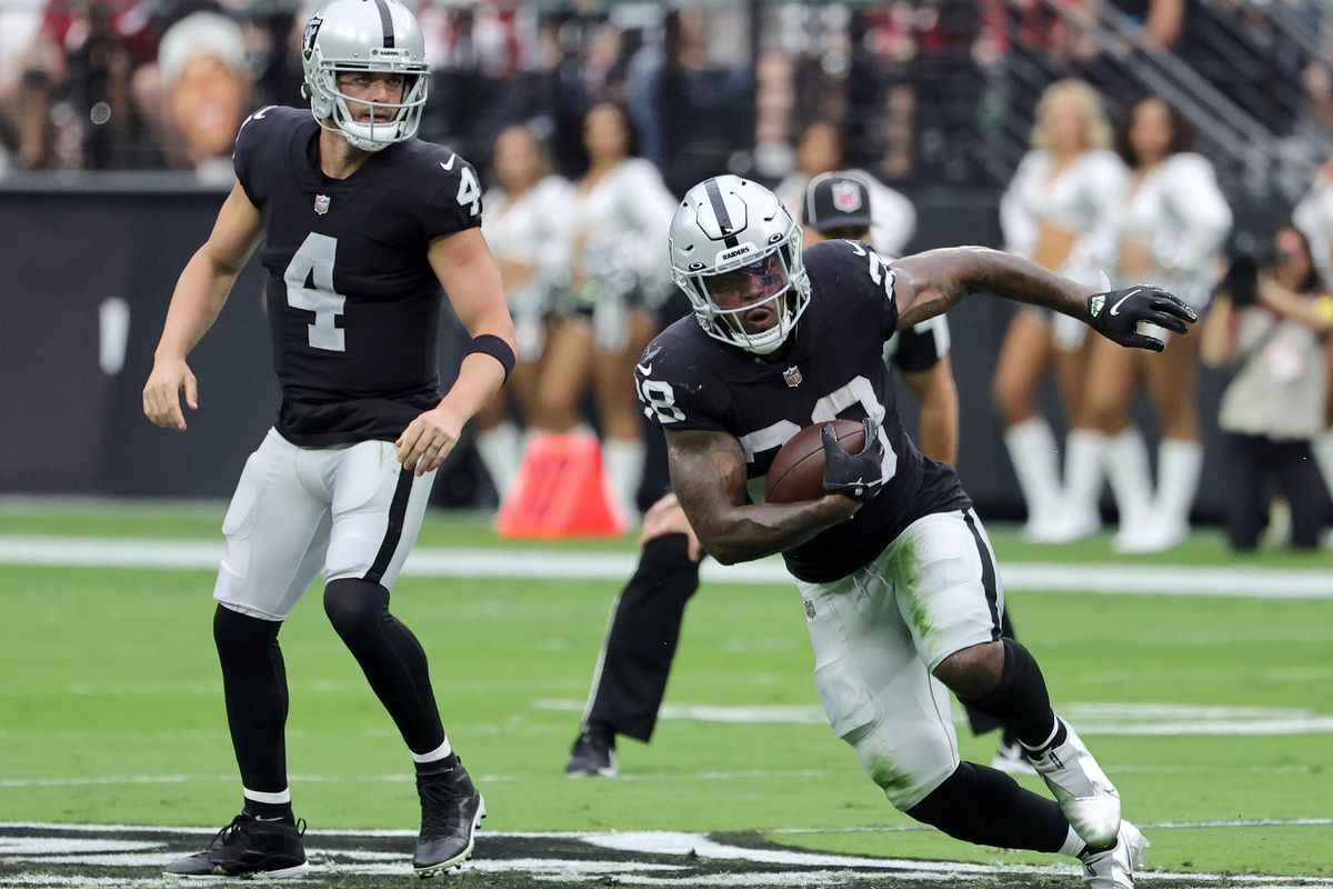Running back Josh Jacobs #28 of the Las Vegas Raiders runs against the Arizona Cardinals after taking a handoff from quarterback Derek Carr #4 of the Las Vegas Raiders during their game at Allegiant Stadium on September 18, 2022 in Las Vegas, Nevada.