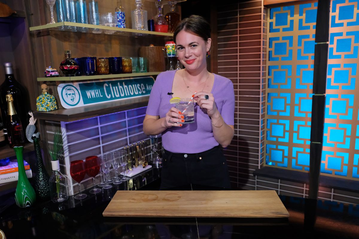 Alison Roman holding a drink on a show set.