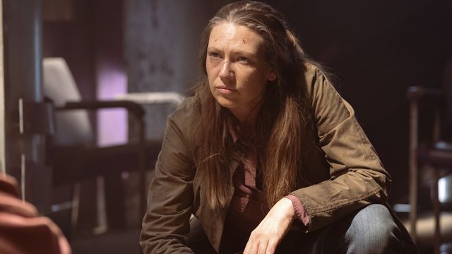 Tess (Anna Torv) crouches down in a dank underground bunker in The Last of Us