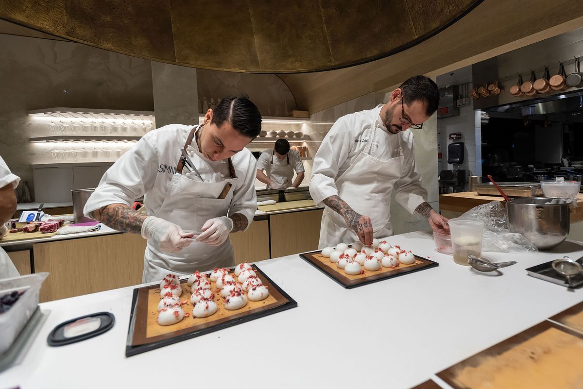 Workers assemble elaborate dishes at two-Michelin-star restaurant Somni.