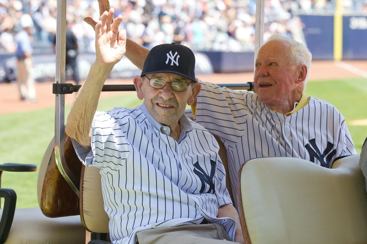 Yogi Berra and Whitey Ford raise their hands after the Yankees ask if anyone else can go a few innings.