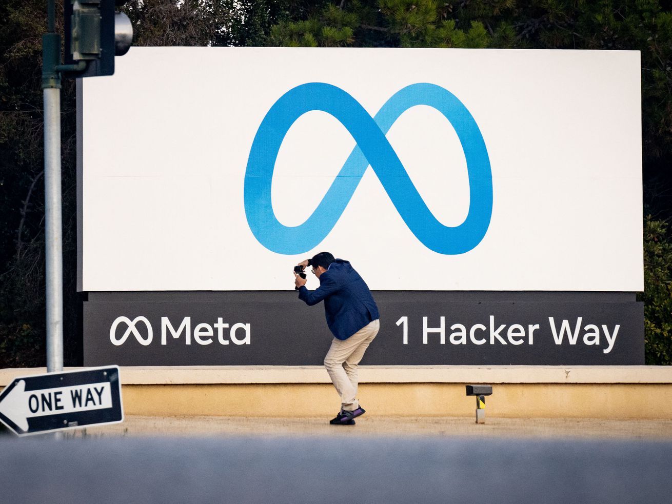 A person taking a picture of the Meta sign at 1 Hacker Way.