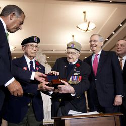 Eugene Gutierrez, Jr., second from left, and Charles Mann from Canada, third from left, is presented by House Speaker John Boehner of Ohio, left, with the Congressional Gold Medal on behalf of the members of the First Special Service Force, whose fearlessness and bravery contributed to the liberation of Europe and end to World War II during a ceremony on Capitol Hill in Washington, Tuesday, Feb. 3, 2015. Boehner is accompanied by, from fourth from left to right, Senate Majority Leader Mitch McConnell, R-Ky., Sen. Dick Durbin, D-Ill. and House Minority Leader Nancy Pelosi of Calif. 