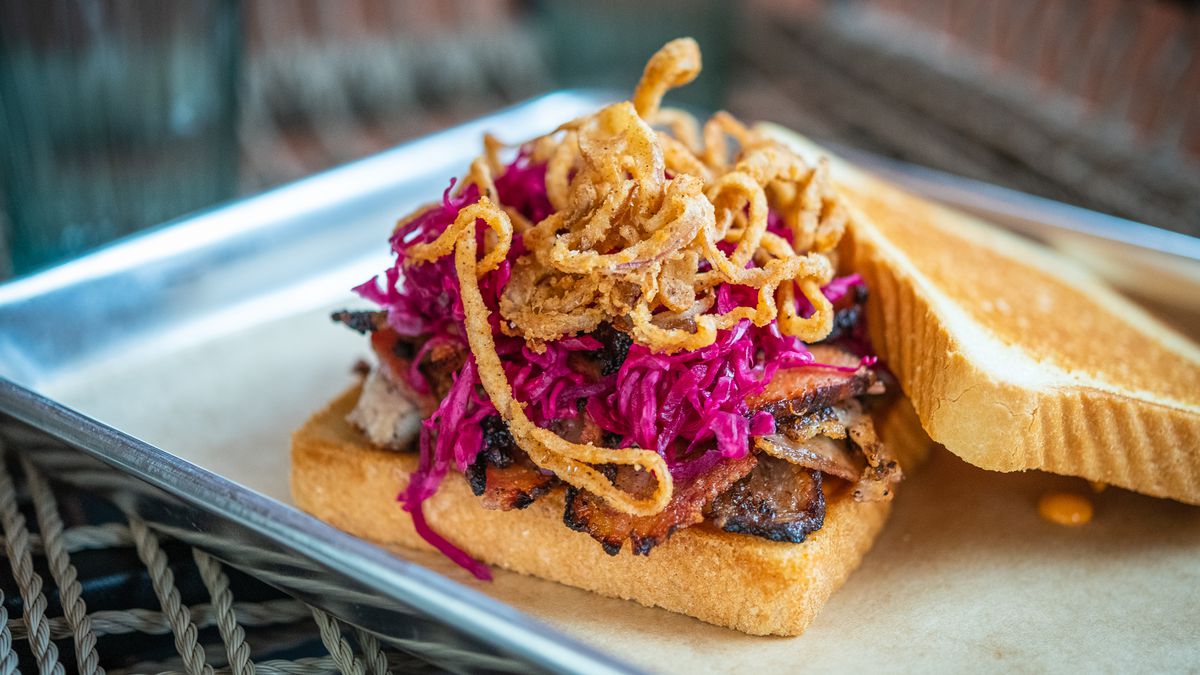 A smoked pork belly pastrami sandwich at Lulu’s Winegarden comes on Texas Toast with fermented red cabbage, pickles, lots of crispy shallots, and an aioli made from pork drippings