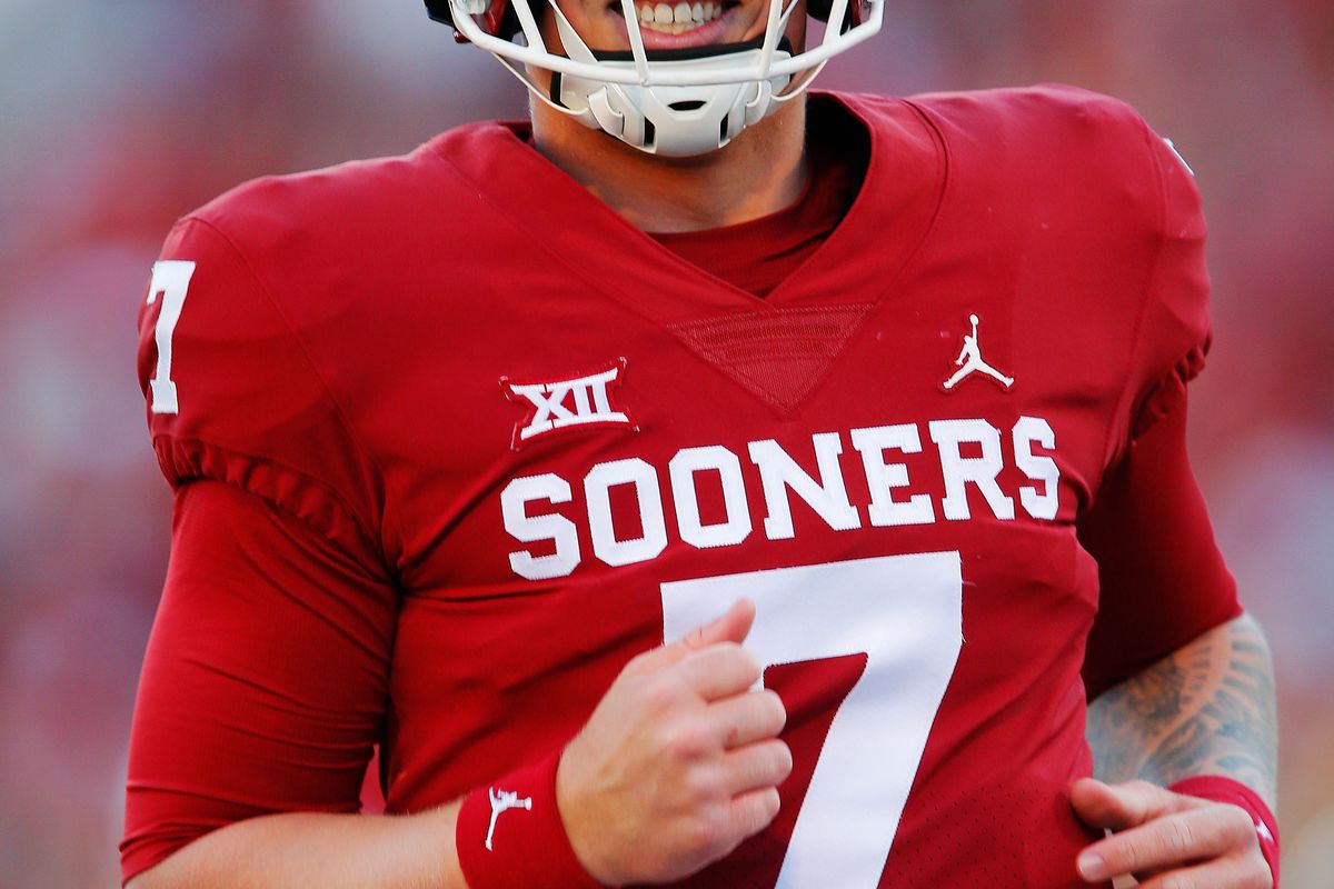 Quarterback Spencer Rattler of the Oklahoma Sooners smiles after throwing a 42-yard pass to the end zone for a touchdown against the Texas Tech Red Raiders in the fourth quarter at Gaylord Family Oklahoma Memorial Stadium on October 30, 2021 in Norman, Oklahoma.