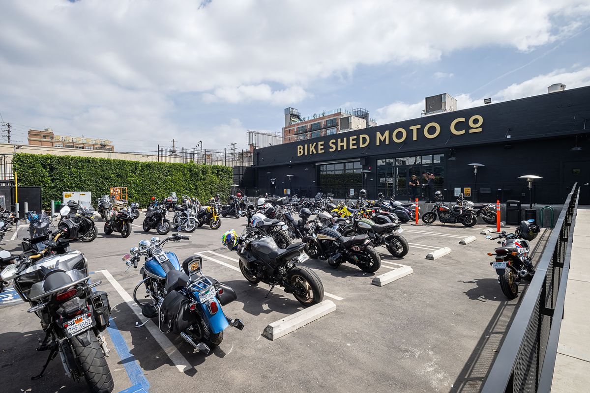 A collection of motorcycles in front of a large warehouse.