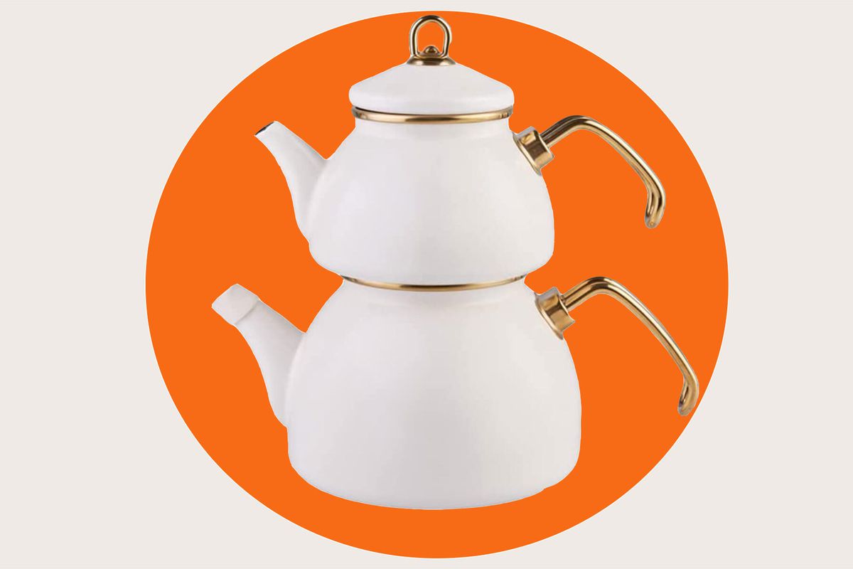 A porcelain double teapot with bronze handles and rims, against an abstract background 
