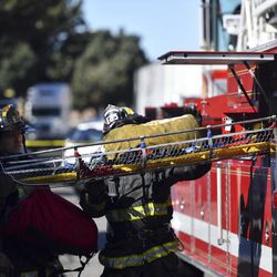 A stretcher is taken out of a fire truck at the scene of a fire that destroyed a warehouse Saturday, Dec. 3, 2016, in Oakland, Calif. A deadly fire broke out during a rave at the converted warehouse in the San Francisco Bay Area. 