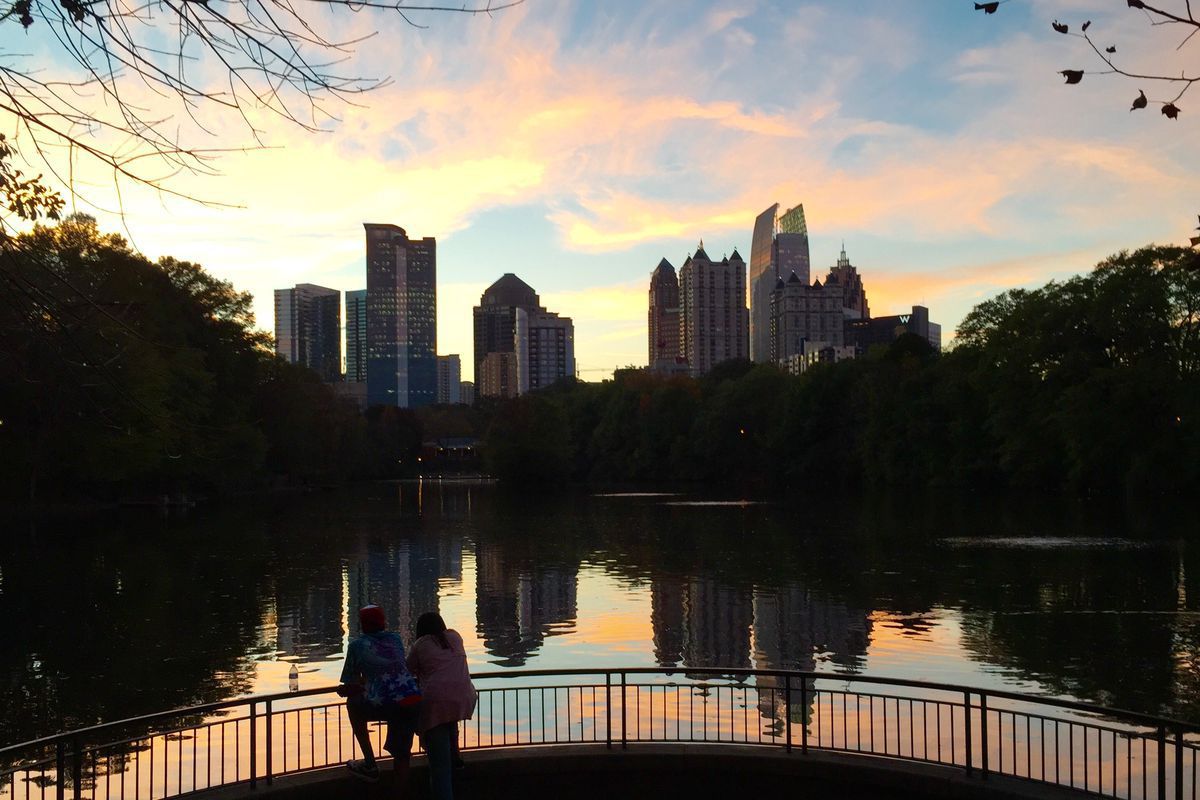 A photo of staycation hotspot Midtown reflected in Lake Clara Meer, Piedmont Park.
