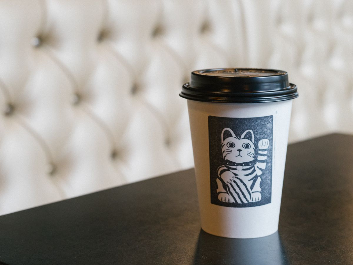 A cup with a cat stamp on it at Either/Or