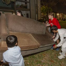 Mohammad Qazikhil, left, Omid Momand, 9, Anthony Buchanan, 18, and Zahirullah Qazikhil, 15, lift a couch that was collected through the Giving Machine as part of The Church of Jesus Christ of Latter-day Saints’ Light the World initiative on Dec. 10, 2021 in San Antonio, Texas.